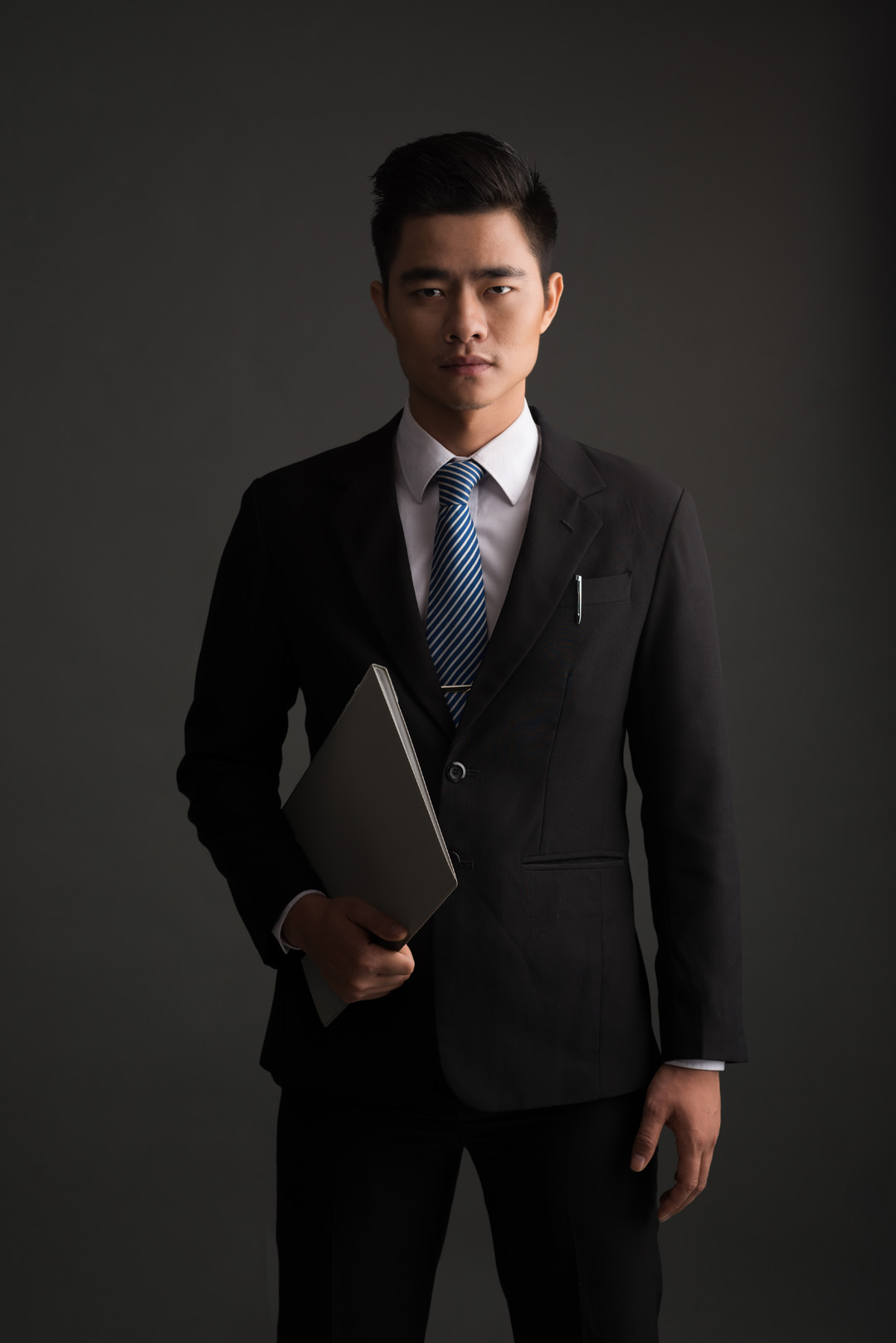 Portrait of confident young Vietnamese businessman, isolated on grey